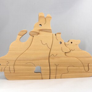 Wooden Wolf Family Stacking Puzzle is handmade from hardwood and finished with mineral oil, beeswax, and carnauba wax. Freestanding interlocking wolf family puzzle pieces shown assembled. Approximate size 10.5 inches long by 6.7 inches high by 3/4 inch thick. Handmade in Tallahassee, Florida, USA.