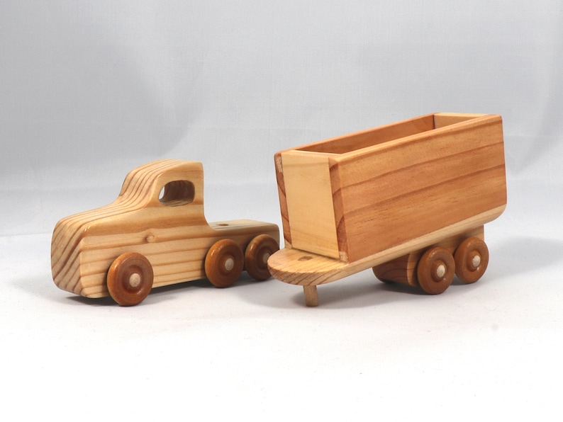Handmade wooden toy tractor trailer semi truck finished with clear shellac. Crafted from natural wood using traditional woodworking tools. Approximate size 7 inches long. Made in Tallahassee, Florida, USA from Odin's Toy Factory Play Pal Collection.