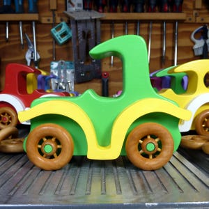Handmade wooden toy car, vintage-style Model T sedan, painted bright green and yellow with spoked wheels, finished in amber shellac.  Handcrafted in Tallahassee, Florida, USA by Odin's Toy Factory.
