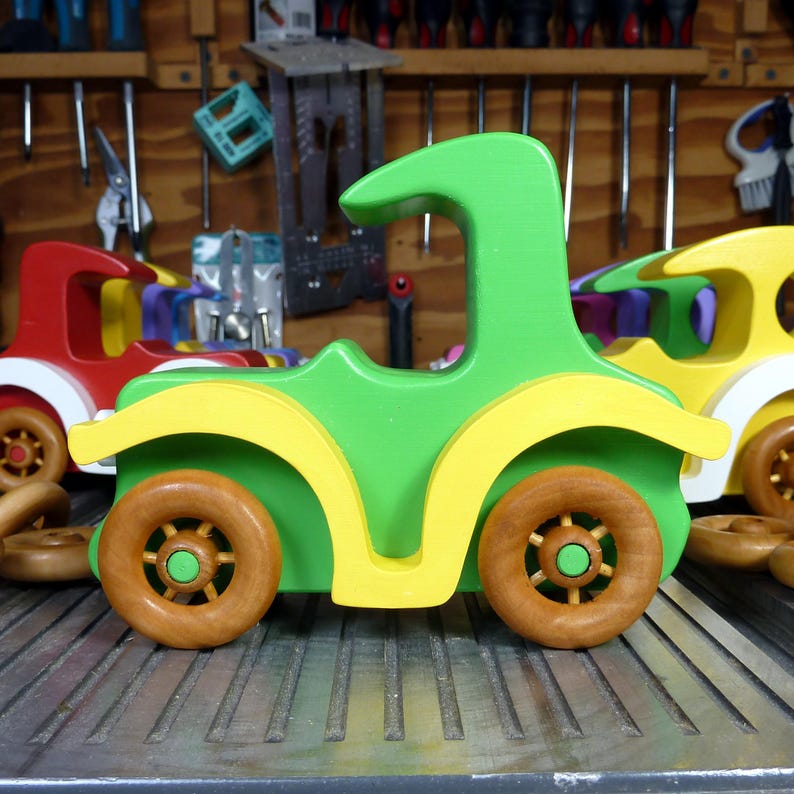 Handmade wooden toy car, vintage-style Model T sedan, painted bright green and yellow with spoked wheels, finished in amber shellac.  Handcrafted in Tallahassee, Florida, USA by Odin's Toy Factory.