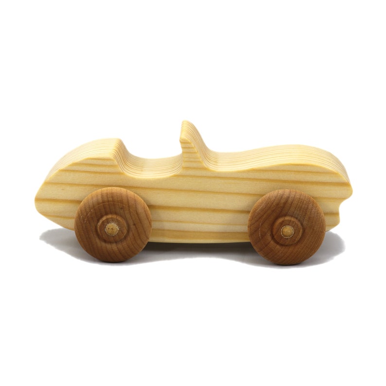 A small, handcrafted wooden toy convertible sports car, finished with a custom blend of oils and waxes, is the perfect gift for young children.