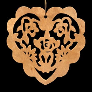 A handmade wooden Victorian-style fretwork floral heart Christmas tree ornament, featuring intricate cutout floral patterns in a heart shape, with a warm natural wood finish.
