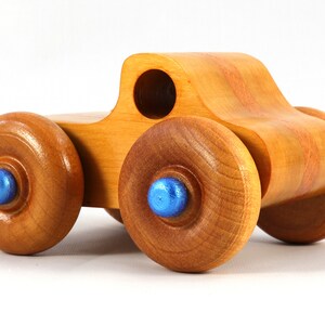 Wood Toy Monster Truck Handmade Form Hardwood and Finished With Amber Shellac With Metallic Saphire Blue Trim.