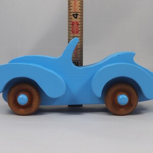 Handmade painted wooden toy car, baby blue convertible with fat fendered roadster design. Non-marring wheels finished with amber shellac.