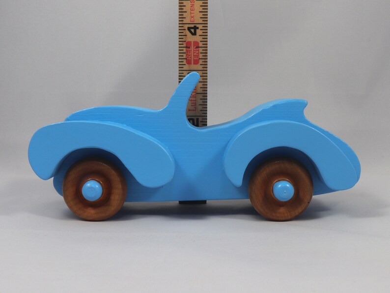 Handmade painted wooden toy car, baby blue convertible with fat fendered roadster design. Non-marring wheels finished with amber shellac.