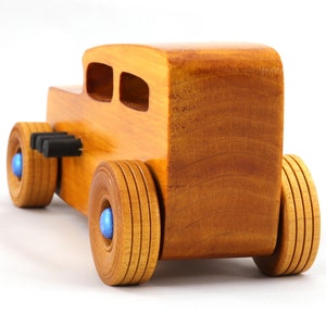 Handcrafted wooden hot rod toy car modeled after a classic '32 sedan. Finished with amber shellac and adorned with metallic sapphire blue and black trim. This unique piece is part of my Hot Rod Collection.