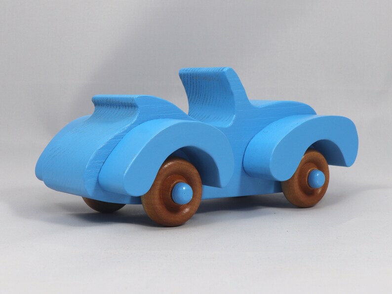 Handmade painted wooden toy car, baby blue convertible with fat fendered roadster design. Non-marring wheels finished with amber shellac.