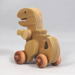 Handmade wooden push toy Tyrannosaurus Rex dinosaur made from select grade hardwoods and finished with a non-toxic coating.