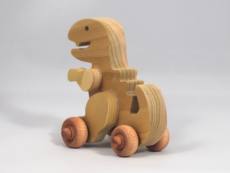 Handmade wooden push toy Tyrannosaurus Rex dinosaur made from select grade hardwoods and finished with a non-toxic coating.