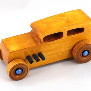 Handcrafted wooden hot rod toy car modeled after a classic '32 sedan. Finished with amber shellac and adorned with metallic sapphire blue and black trim. This unique piece is part of my Hot Rod Collection.
