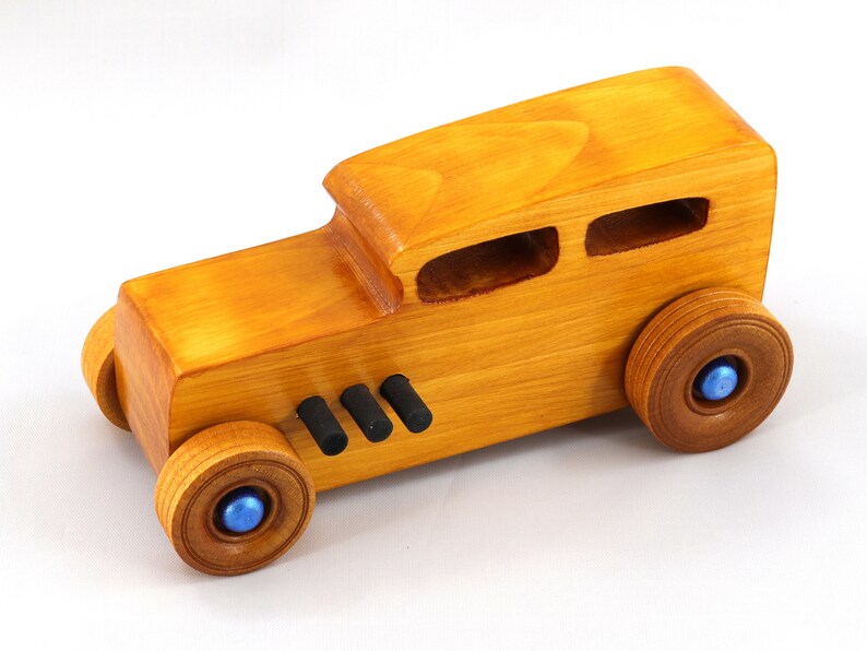 Handcrafted wooden hot rod toy car modeled after a classic '32 sedan. Finished with amber shellac and adorned with metallic sapphire blue and black trim. This unique piece is part of my Hot Rod Collection.