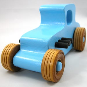 Handmade wooden toy car modeled after a '27 T-Coupe, finished with baby blue and black acrylic paint with nonmarring amber shellac wheels from my hot rod collection.