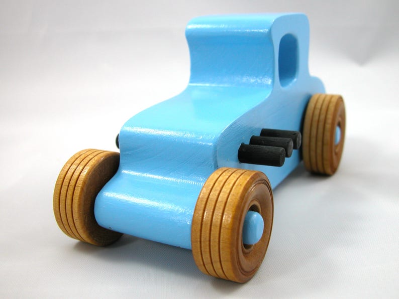 Handmade wooden toy car modeled after a '27 T-Coupe, finished with baby blue and black acrylic paint with nonmarring amber shellac wheels from my hot rod collection.