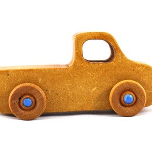 This handmade toy pickup truck from My Play Pal Collection is finished with amber shellac and metallic sapphire blue acrylic paint. It is just one of many unique wooden vehicles available.