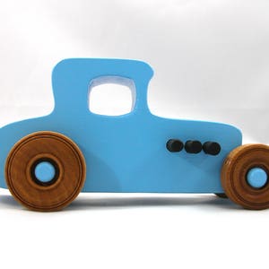 Handmade wooden toy car modeled after a '27 T-Coupe, finished with baby blue and black acrylic paint with nonmarring amber shellac wheels from my hot rod collection.