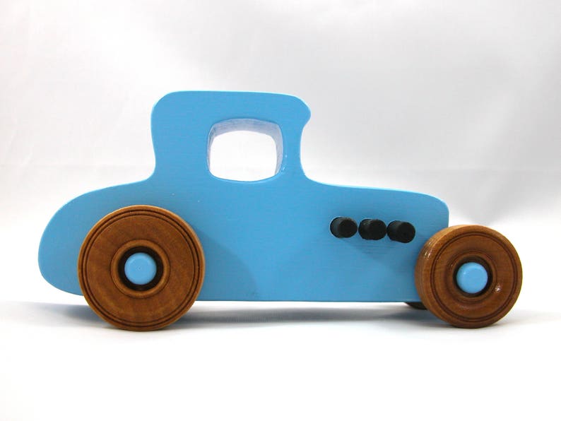 Handmade wooden toy car modeled after a '27 T-Coupe, finished with baby blue and black acrylic paint with nonmarring amber shellac wheels from my hot rod collection.