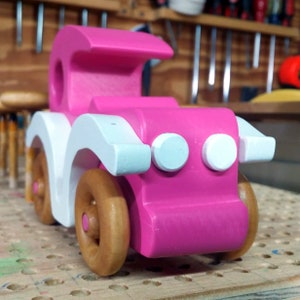 Handmade wooden toy car model-t sedan finished with hot pink and white acrylic paint with nonmaring amber shellac coated spoked wheels from my Bad Bob'S Custom Motors Collection.