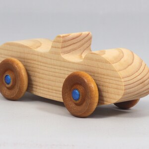 Handmade wooden toy car convertible sports coupe with a nontoxic satin polyethylene finish, amber shellac wheels, and metallic sapphire blue trim.