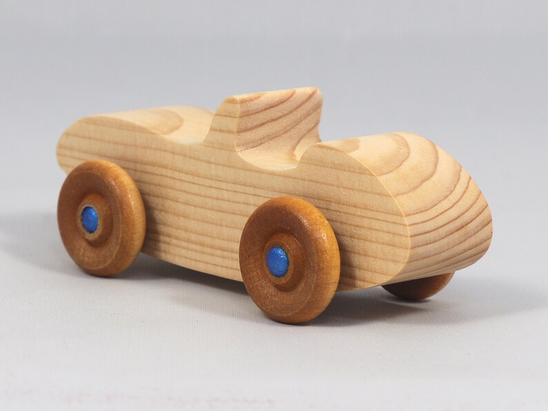 Handmade wooden toy car convertible sports coupe with a nontoxic satin polyethylene finish, amber shellac wheels, and metallic sapphire blue trim.