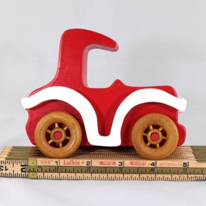 Handmade wooden toy car, vintage style red Model T Coupe by Odin's Toy Factory. Two-tone red and white acrylic paint with spoked wooden wheels finished in amber shellac. Approximate dimensions: 5 inches long, 4 inches high, 2.5 inches wide. Part of Bad Bob’s Custom Motors Collection. Crafted from natural wood using traditional woodworking tools. Handmade in Tallahassee, Florida, USA.