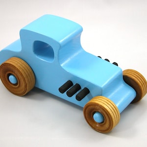 Handmade wooden toy car modeled after a '27 T-Coupe, finished with baby blue and black acrylic paint with nonmarring amber shellac wheels from my hot rod collection.