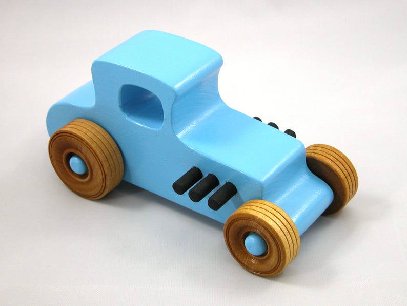 Handmade wooden toy car modeled after a '27 T-Coupe, finished with baby blue and black acrylic paint with nonmarring amber shellac wheels from my hot rod collection.