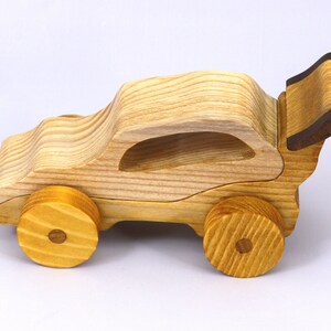Handmade wooden toy car finished with nontoxic clear amber shellac and contrasting wood trim. Part of the Speedy Wheels Collection. Handcrafted in Tallahassee, Florida, USA. Length 5-1/2 inches, width 2-1/2 inches, height 2-1/2 inches. Made at Odin's Toy Factory.