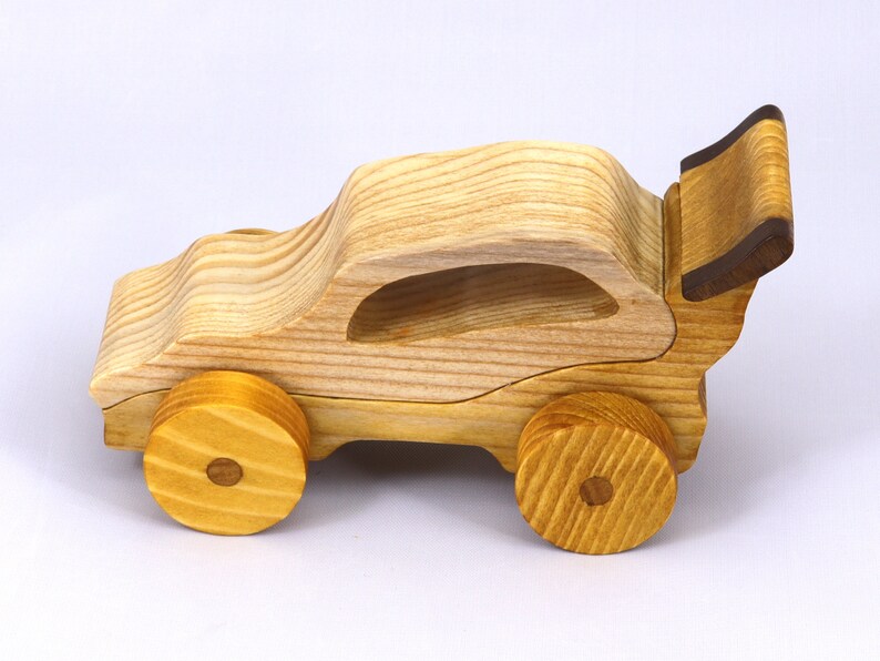 Handmade wooden toy car finished with nontoxic clear amber shellac and contrasting wood trim. Part of the Speedy Wheels Collection. Handcrafted in Tallahassee, Florida, USA. Length 5-1/2 inches, width 2-1/2 inches, height 2-1/2 inches. Made at Odin's Toy Factory.