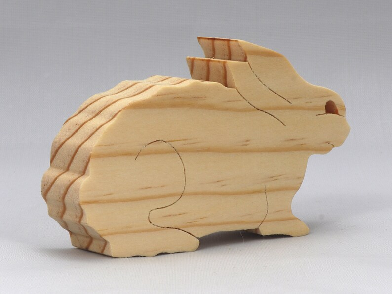 This is an unfinished wooden Rabbit cutout from solid wood using traditional woodworking techniques. Sanded smooth and ready to paint, stain, or customize. Freestanding design for small hands, toddlers, young children, crafters, collectors, and display. I take custom orders for any animal, quantity, and mix — including large ornament orders. Mix and match, request a different size, or send a drawing or pattern. Handmade by Odin's Toy Factory in Tallahassee, Florida, USA.
