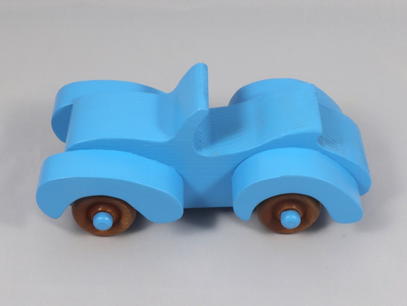 Handmade painted wooden toy car, baby blue convertible with fat fendered roadster design. Non-marring wheels finished with amber shellac.