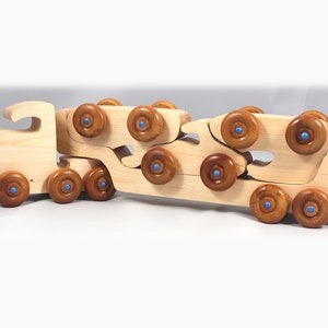Handmade wooden toy truck play set includes three cars and a tractor-trailer finished with clear and amber shellac with metallic sapphire blue trim.