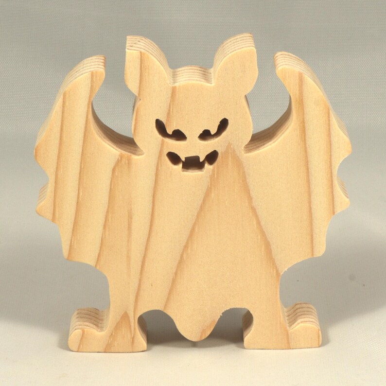 Handmade unpainted wooden Halloween bat cutout, freestanding light-colored solid wood figure with spooky carved face and outstretched wings, ready to paint, from my Snazzy Spooks collection.