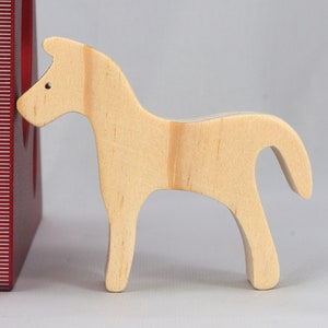 Handmade wooden toy horse cutout, perfect for children's playtime collection. Freestanding and stackable, ready to paint or customize. Endless possibilities for imaginative play, from farm scenes to towering animal creations.