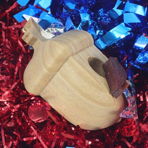 Handmade wooden miniature birdhouse ornament cut from wood with rounded edges, natural wood grain and color variations, finished with non-toxic shellac or food-safe oils and beeswax, lightweight and ready to hang. Made in Tallahassee, Florida, USA, by Odin's Toy Factory.