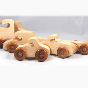 Handmade wooden toy truck play set includes three cars and a tractor-trailer finished with clear and amber shellac with metallic sapphire blue trim.
