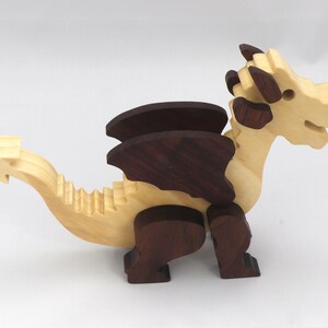 Wood Dragon Fantasy Animal Figurine is Handmade and finished with a renewable blend of mineral oil and waxes Applied hot for durabiliity and to enhance the beauty of the wood. There are ten dragons in this collection. A  link is in the description.