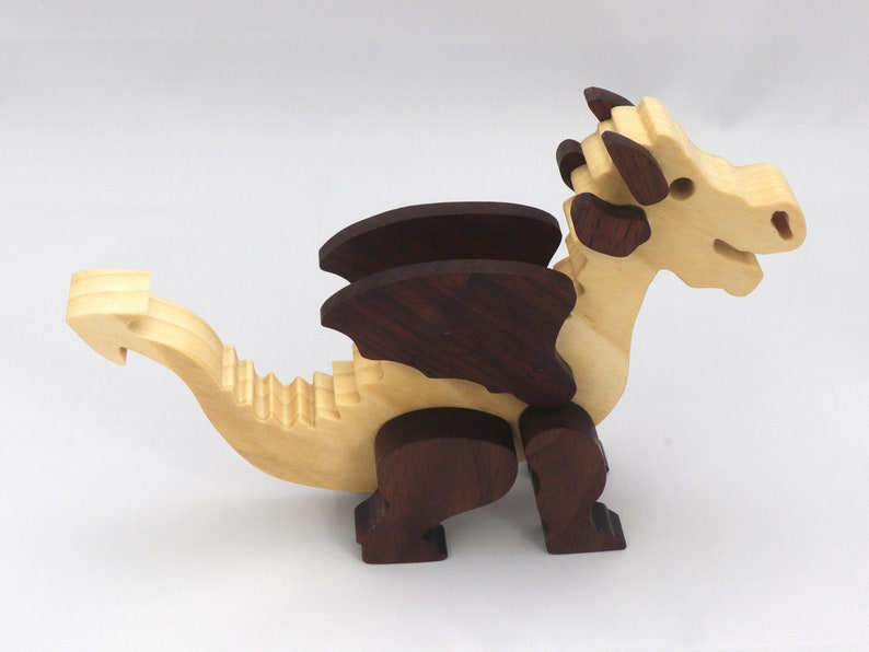 Wood Dragon Fantasy Animal Figurine is Handmade and finished with a renewable blend of mineral oil and waxes Applied hot for durabiliity and to enhance the beauty of the wood. There are ten dragons in this collection. A  link is in the description.