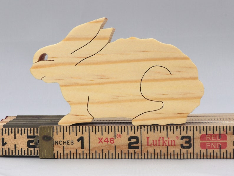 This is an unfinished wooden Rabbit cutout from solid wood using traditional woodworking techniques. Sanded smooth and ready to paint, stain, or customize. Freestanding design for small hands, toddlers, young children, crafters, collectors, and display. I take custom orders for any animal, quantity, and mix — including large ornament orders. Mix and match, request a different size, or send a drawing or pattern. Handmade by Odin's Toy Factory in Tallahassee, Florida, USA.