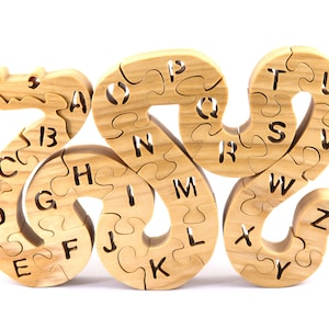 Hand-cut Alphabet Snake Puzzle made from premium hardwood, finished with mineral oil and beeswax for durability. Each of the 26 pieces represents a letter, promoting alphabet learning and essential skills development in kids through play.