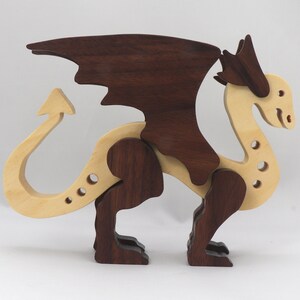 Handmade wooden dragon figurine made from contrasting hardwoods with a light natural wood body and head paired with rich dark reddish-brown wings, legs, and horns.