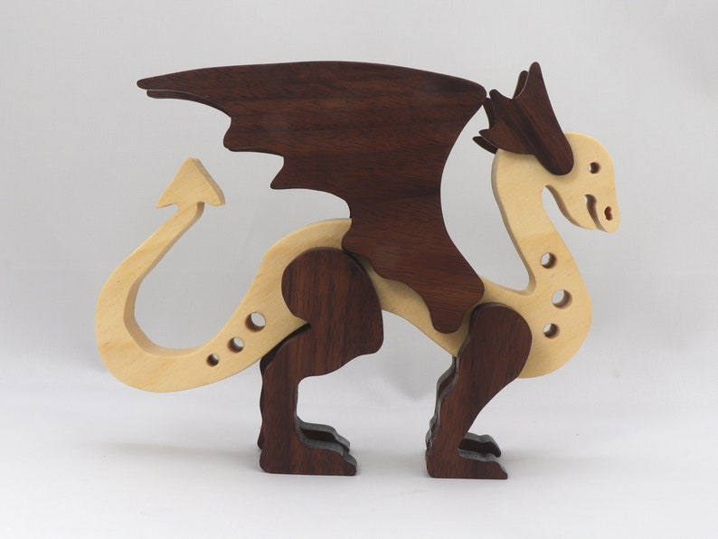 Handmade wooden dragon figurine made from contrasting hardwoods with a light natural wood body and head paired with rich dark reddish-brown wings, legs, and horns.