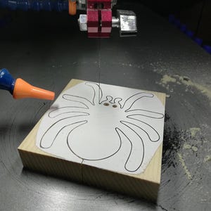 Handmade unfinished wooden Halloween spider cutout from Odin's Toy Factory Snazzy Spooks Collection. Solid wood hand-cut spider, paintable, freestanding design. Approximate size 3.5 inches height by 3.5 inches width by 0.75 inches thick. Made in Tallahassee, Florida, USA.