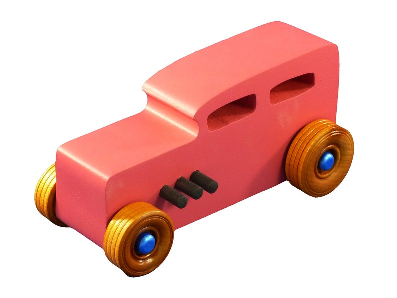Handcrafted pink wooden hot rod '32 sedan toy car. Features black and metallic sapphire blue accents, and non-marking amber shellac wheels. Made to order for unique play or display.