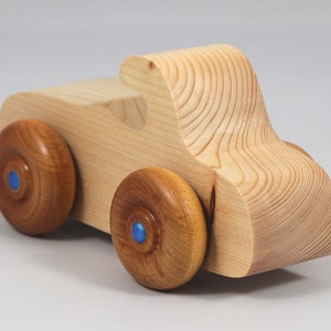 Handmade wooden toy car. The body is finished with clear shellac, and the wheels are finished with amber shellac. The hubs are painted with metallic sapphire blue trim.