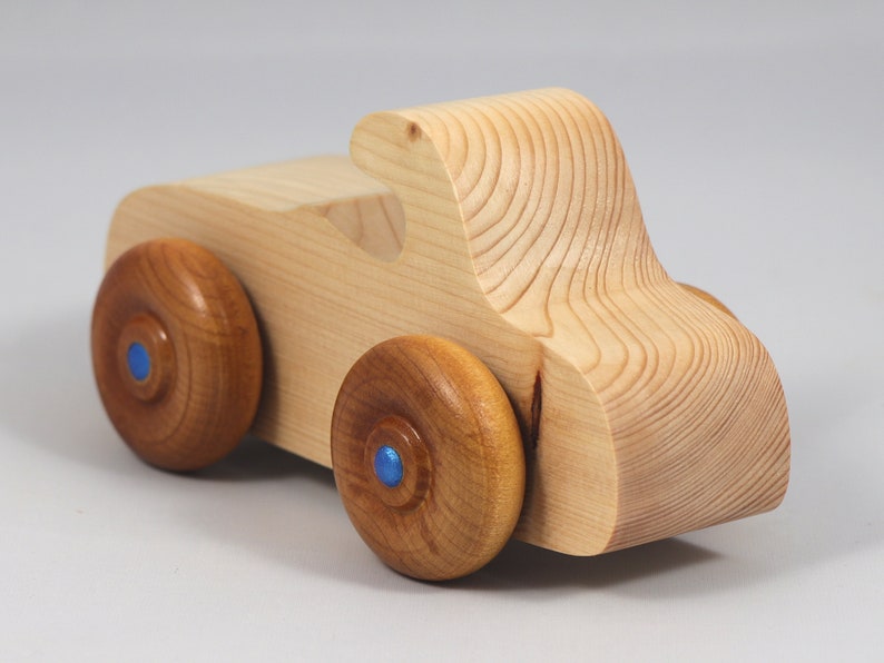 Handmade wooden toy car. The body is finished with clear shellac, and the wheels are finished with amber shellac. The hubs are painted with metallic sapphire blue trim.
