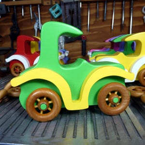 Handmade wooden toy car, vintage-style Model T sedan, painted bright green and yellow with spoked wheels, finished in amber shellac.  Handcrafted in Tallahassee, Florida, USA by Odin's Toy Factory.