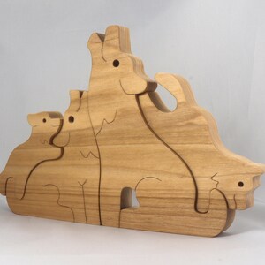 Wooden Wolf Family Stacking Puzzle is handmade from hardwood and finished with mineral oil, beeswax, and carnauba wax. Freestanding interlocking wolf family puzzle pieces shown assembled. Approximate size 10.5 inches long by 6.7 inches high by 3/4 inch thick. Handmade in Tallahassee, Florida, USA.