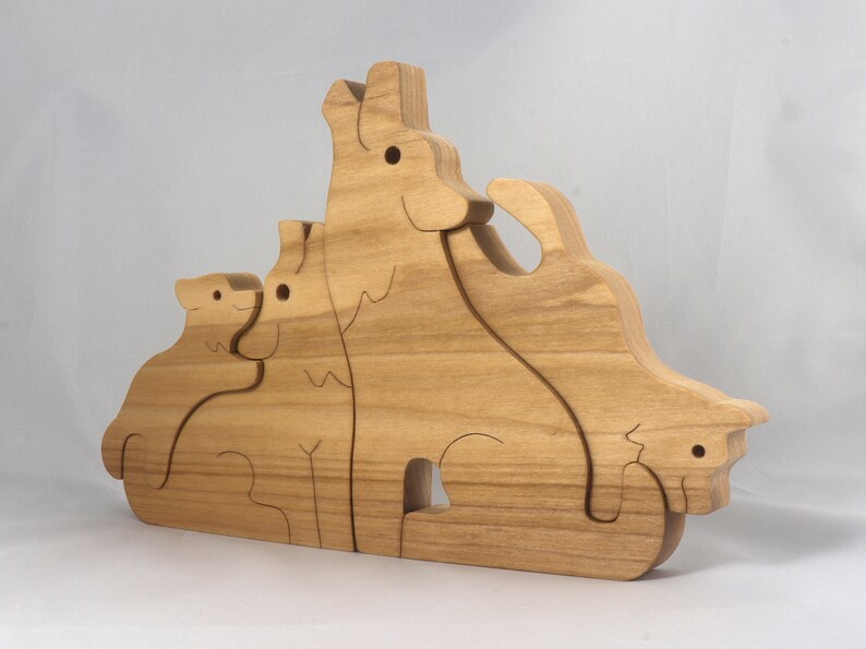 Wooden Wolf Family Stacking Puzzle is handmade from hardwood and finished with mineral oil, beeswax, and carnauba wax. Freestanding interlocking wolf family puzzle pieces shown assembled. Approximate size 10.5 inches long by 6.7 inches high by 3/4 inch thick. Handmade in Tallahassee, Florida, USA.