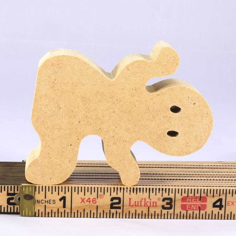 A handmade, unpainted wooden ghost cutout stands upright on a white background. The light-colored solid wood figure has a rounded head with two circular eye cutouts, raised wavy arms, and a curved wavy base, ready for painting or crafting.