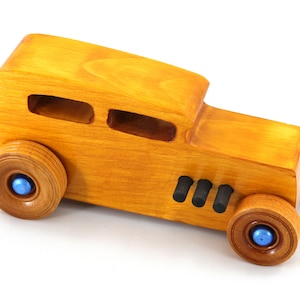Handcrafted wooden hot rod toy car modeled after a classic '32 sedan. Finished with amber shellac and adorned with metallic sapphire blue and black trim. This unique piece is part of my Hot Rod Collection.